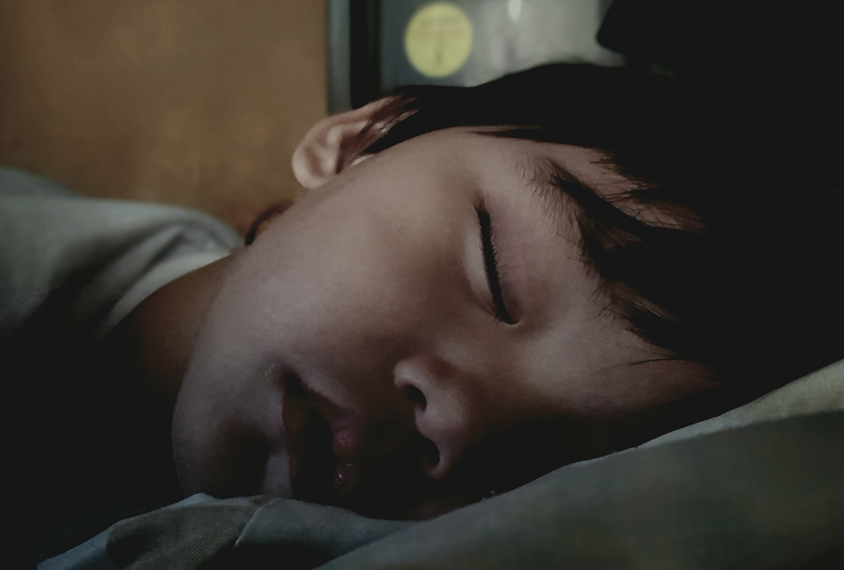 Boy sleeping in low light